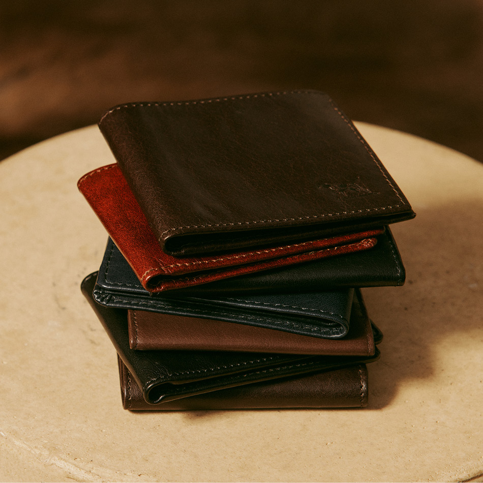 Stack of men's leather wallets in brown, tan and black.