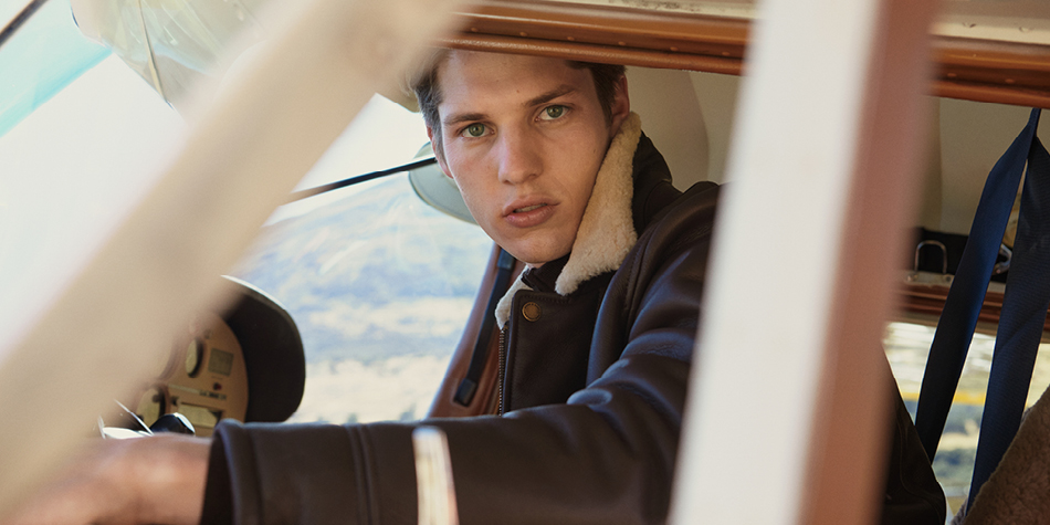 Model wearing brown leather shearling jacket.