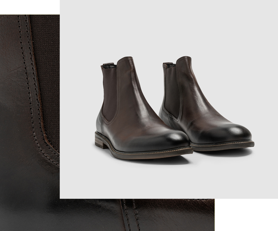Image of men's leather boots on a wooden plinth.