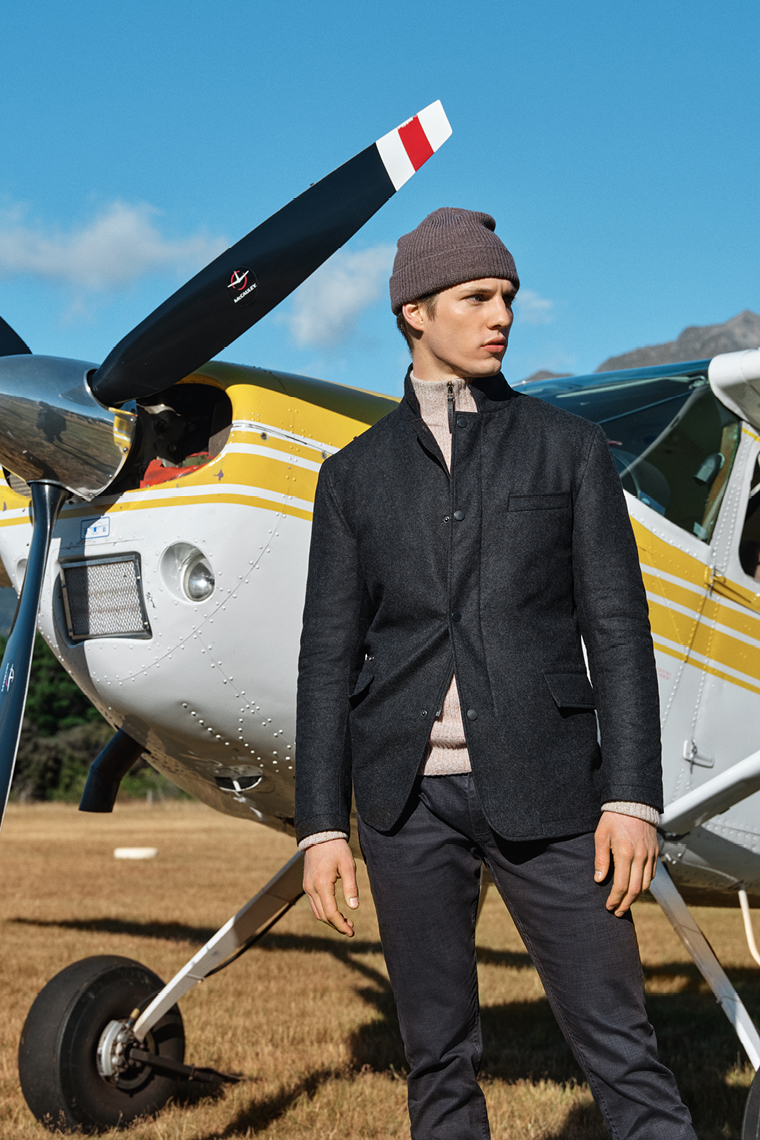 Rodd & Gunn dark blazer, brown beanie, a light coloured knit and dark pants.