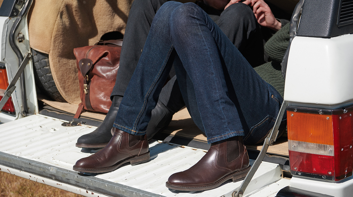 Rodd & Gunn's dark blue jeans and brown leather boots.