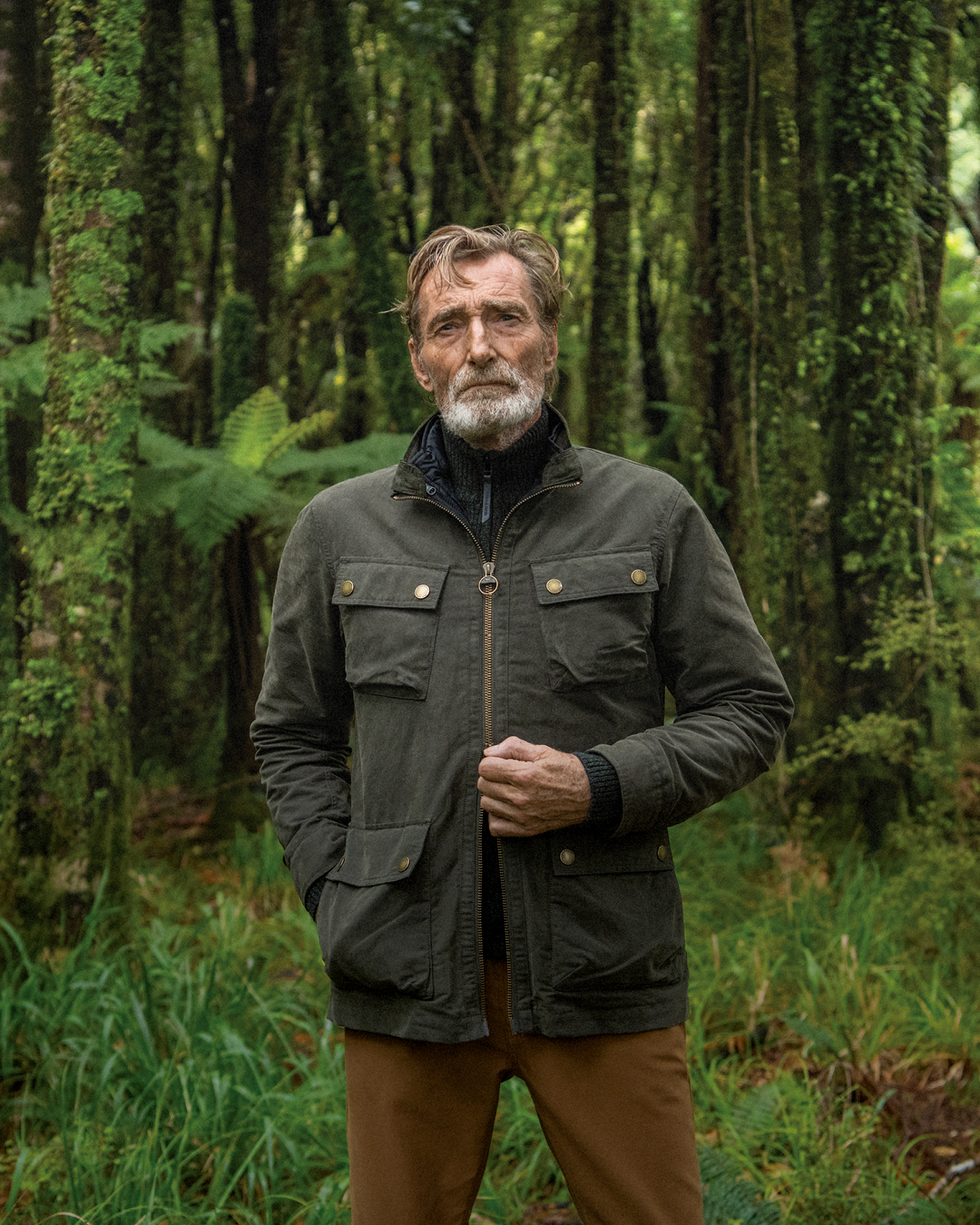 A man leaning on the wall, wearing the Blackpool Easy Fit Jacket and Halls Creek Pants.