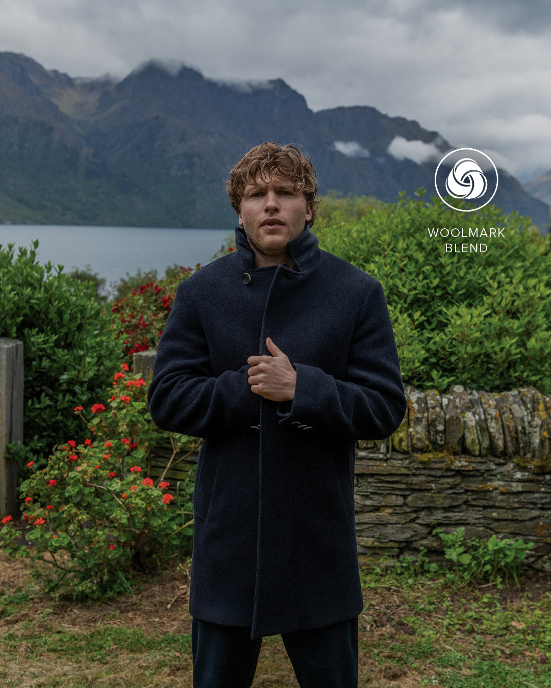 A man in a stylish coat stands outside a house, adding character to the picturesque setting.