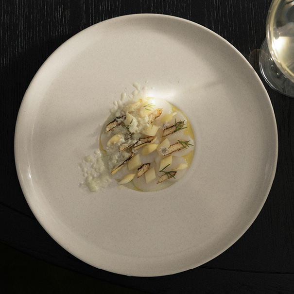 Artfully arranged meal on a clean plate, showcasing fresh ingredients and fine dining presentation.